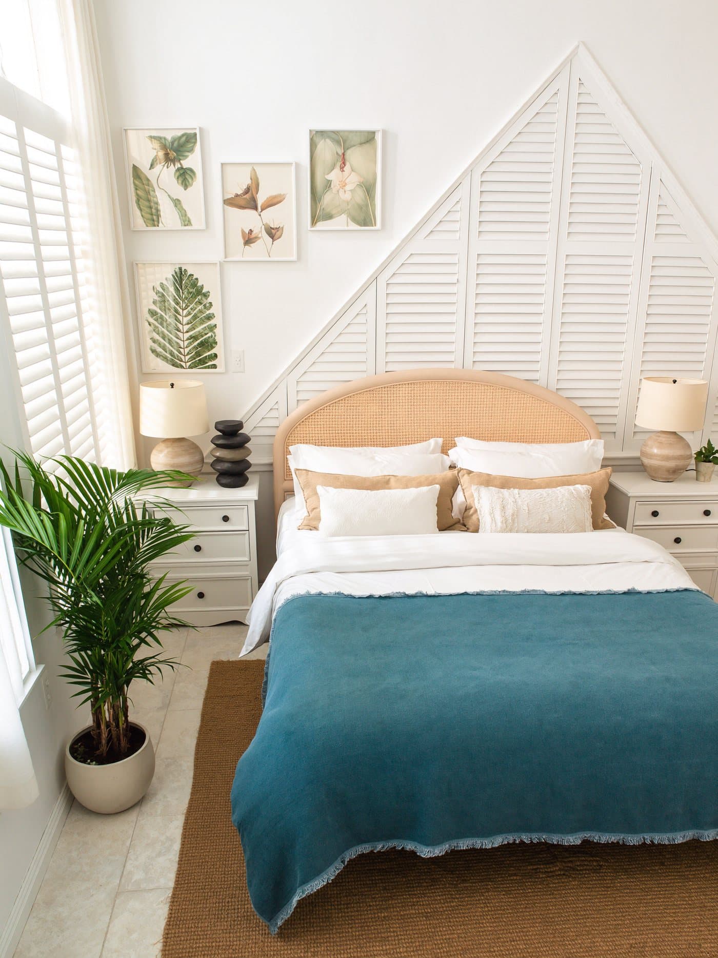 Bedroom of a Cozy Corner rental with a rattan headboard, white bedding and a teal throw, made up for the next guest